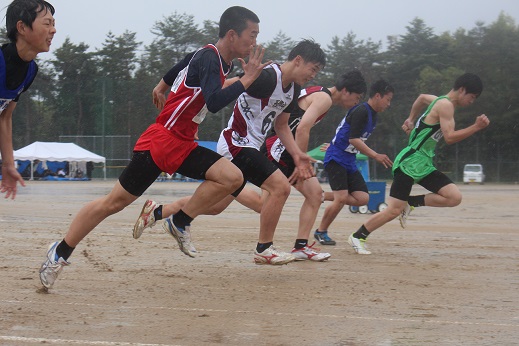 グラウンドでユニフォームを着た生徒たちがスタートの合図とともに全力で走っている写真