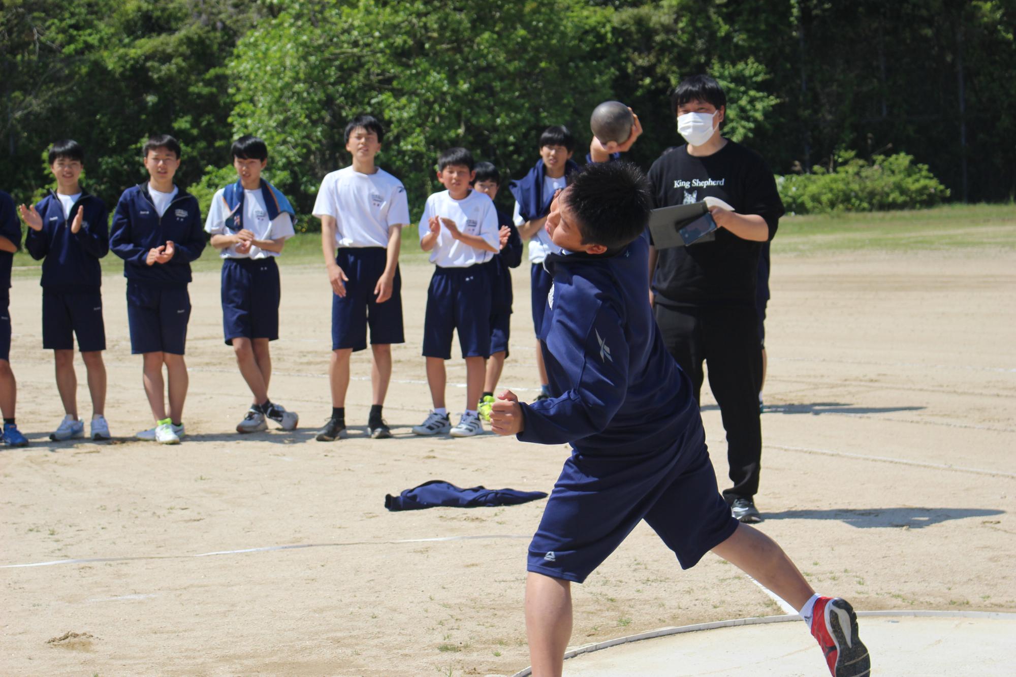 校庭で生徒がボールを投げて競技をしている写真
