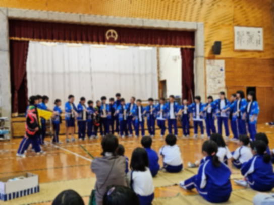 体育館で楽器演奏を披露するたくさんの児童の写真