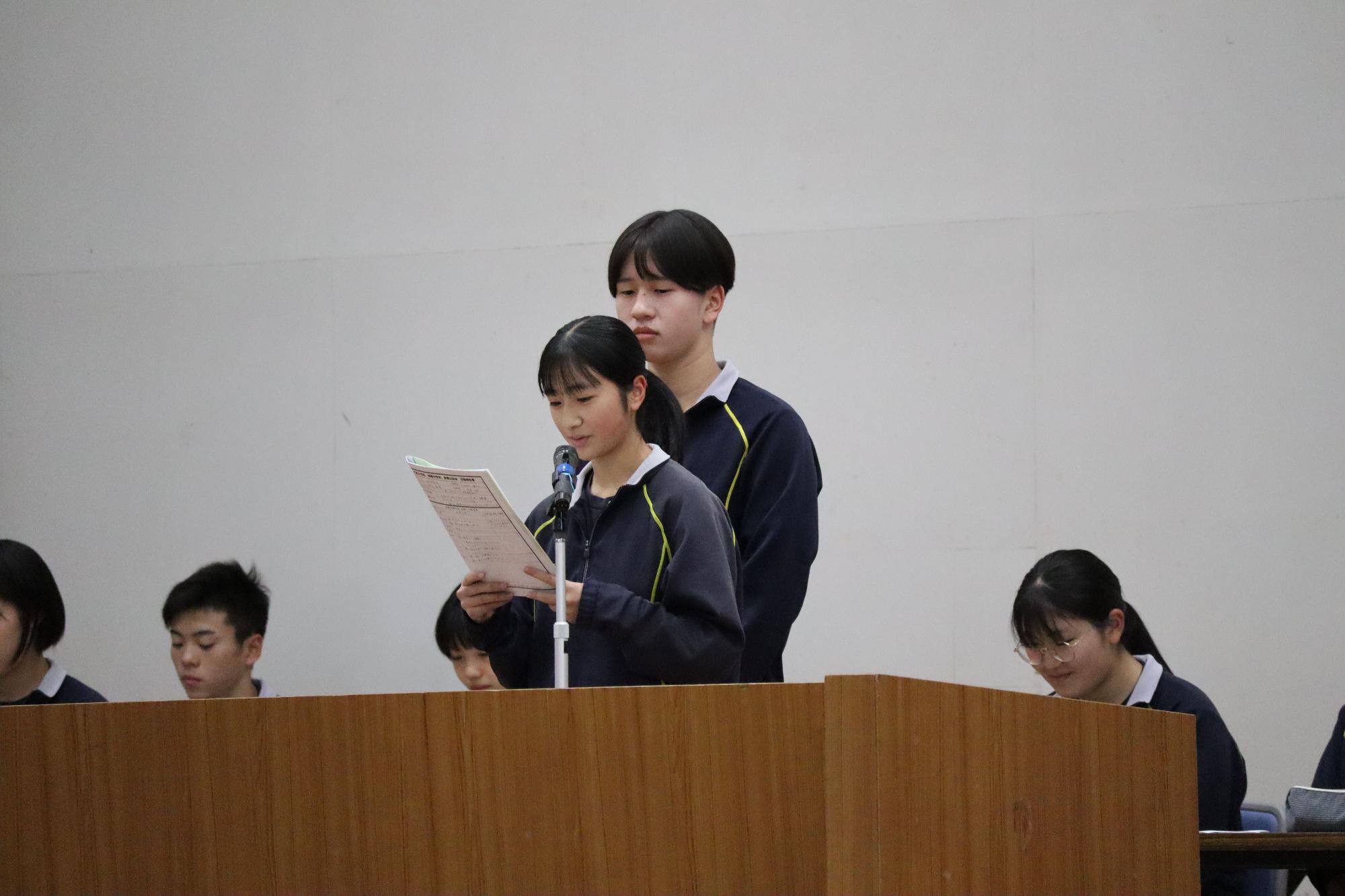 体育館で生徒が代表あいさつをする写真