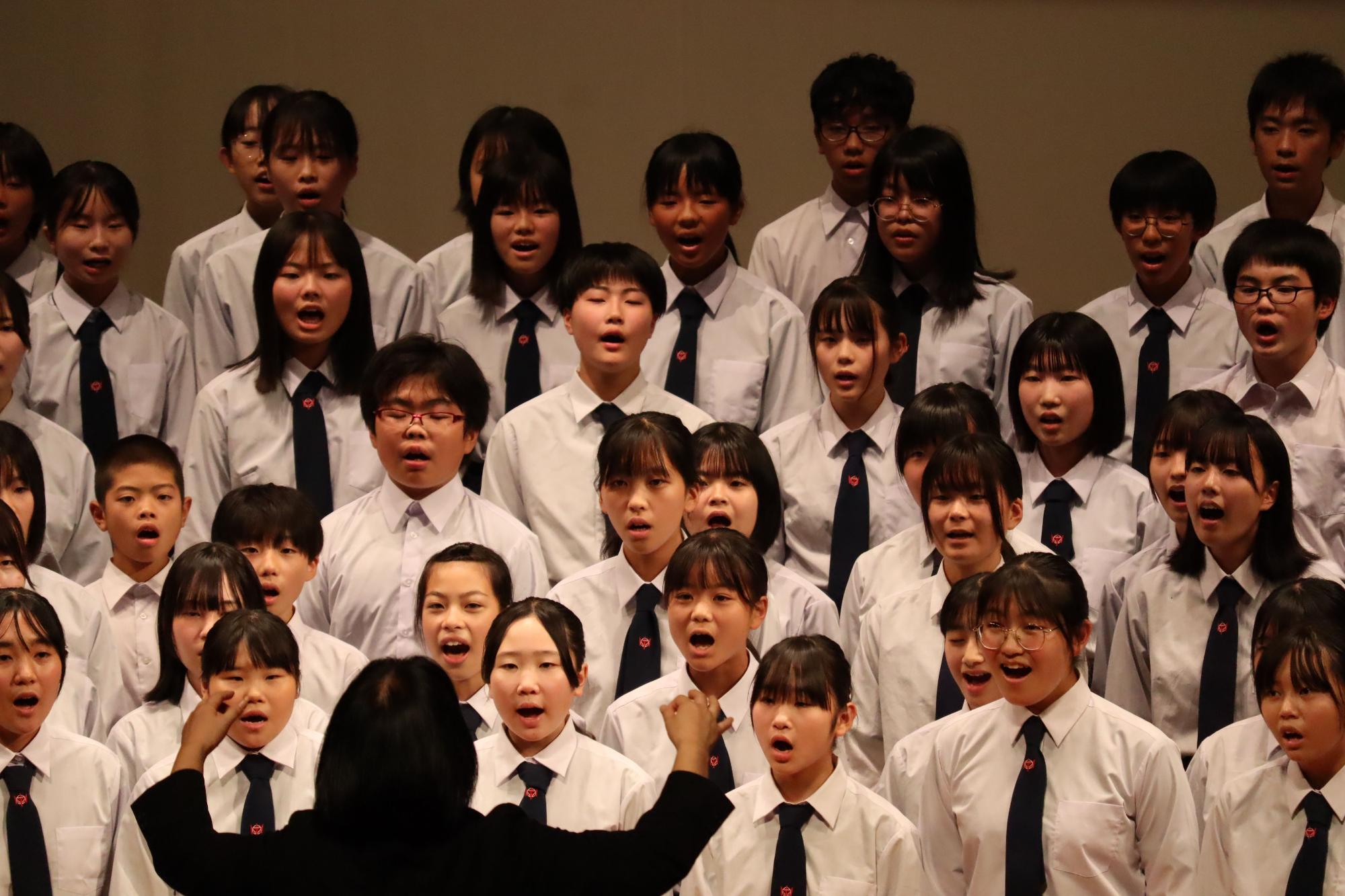 ステージで生徒たちが合唱をする写真