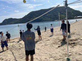 海辺で生徒たちが砂浜バレーをしている写真
