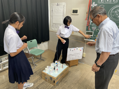 教室で生徒と来校者が釣りゲームをしている写真