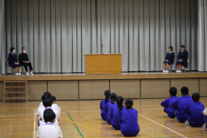 体育館のステージで生徒たちが壇上で発表をしている写真