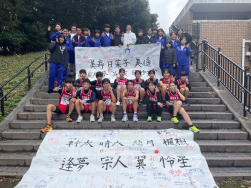 学校の階段で駅伝チームが横断幕とともに記念撮影をしている写真