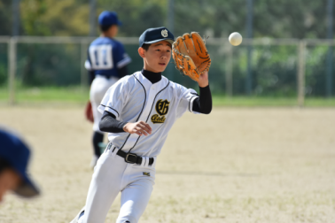 野球場で生徒がボールをキャッチしようとしている写真
