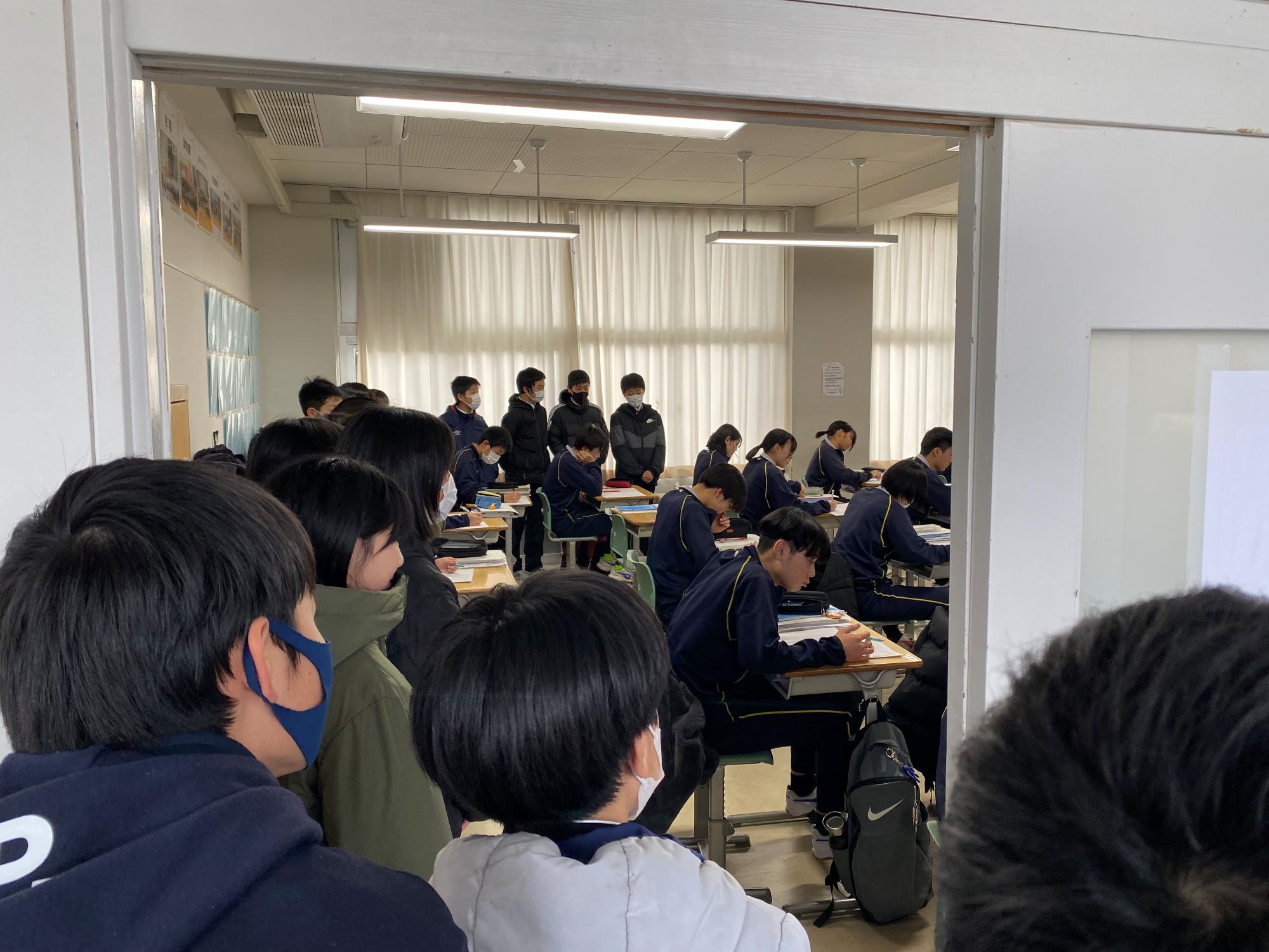 一日入学の児童を廊下から見守る生徒たちの写真