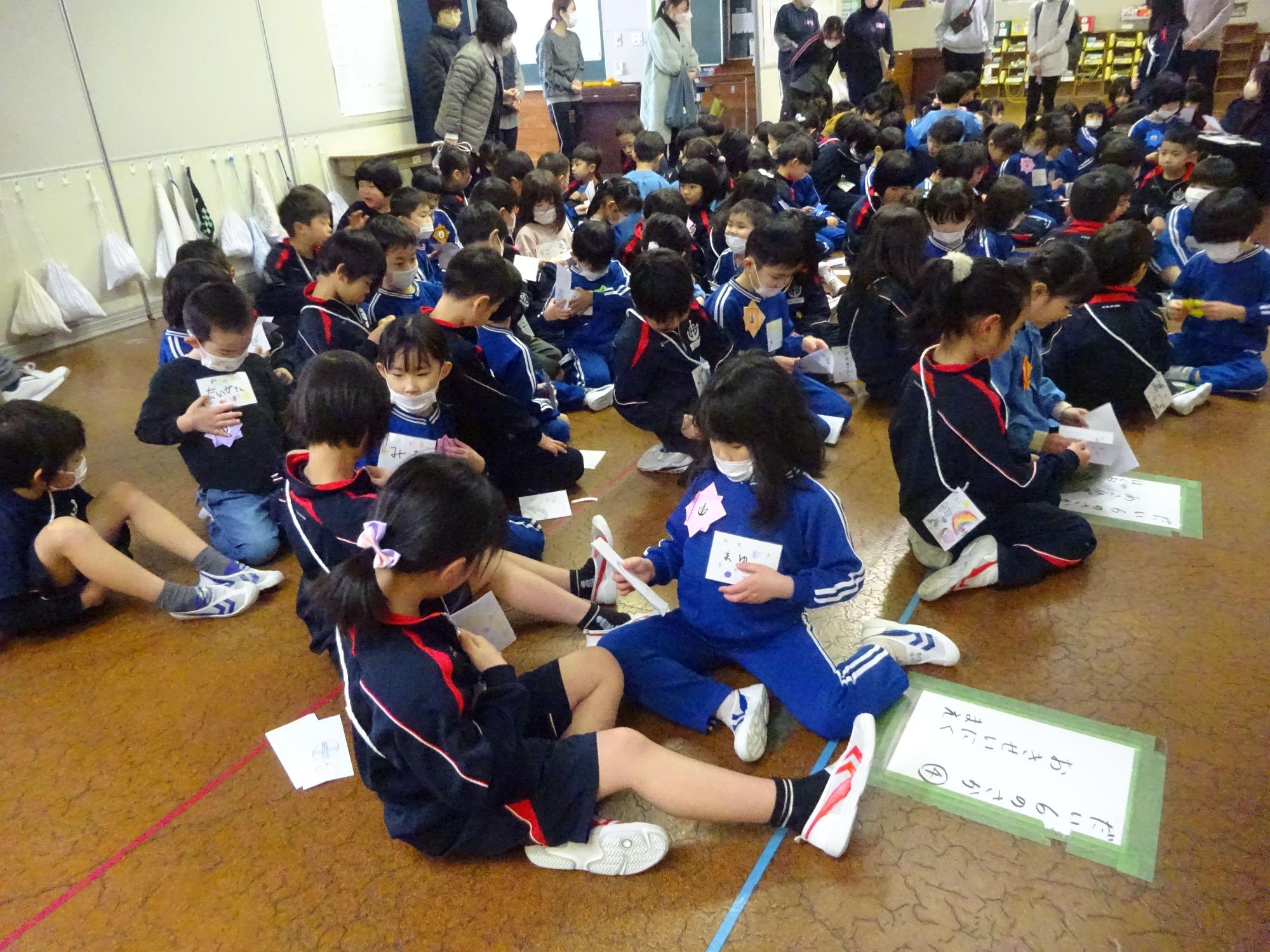床に座ってカードを確認し合う児童たちの写真