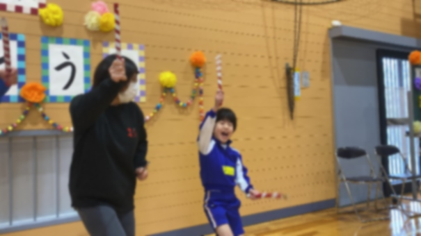 体育館で児童が保護者と一緒にダンスを踊って楽しんでいる様子の写真