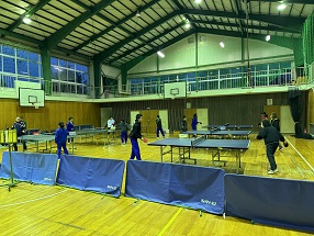 体育館で生徒たちが卓球の練習をしているところを横から撮影した写真