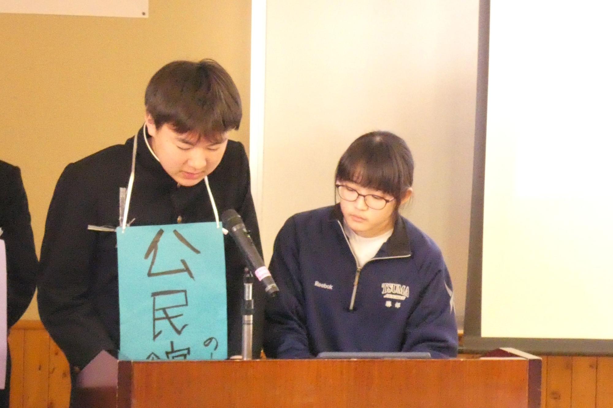 教室の前で資料を見ながら発表をする生徒たちの写真