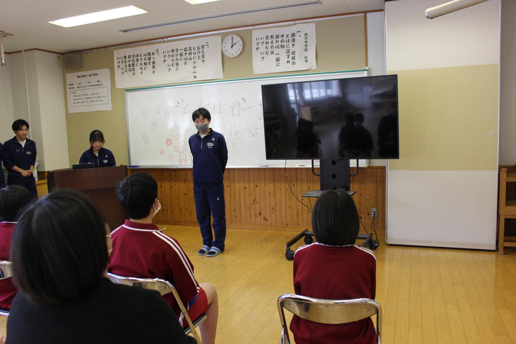 教室で在校生の前に立って自己紹介をする生徒の写真