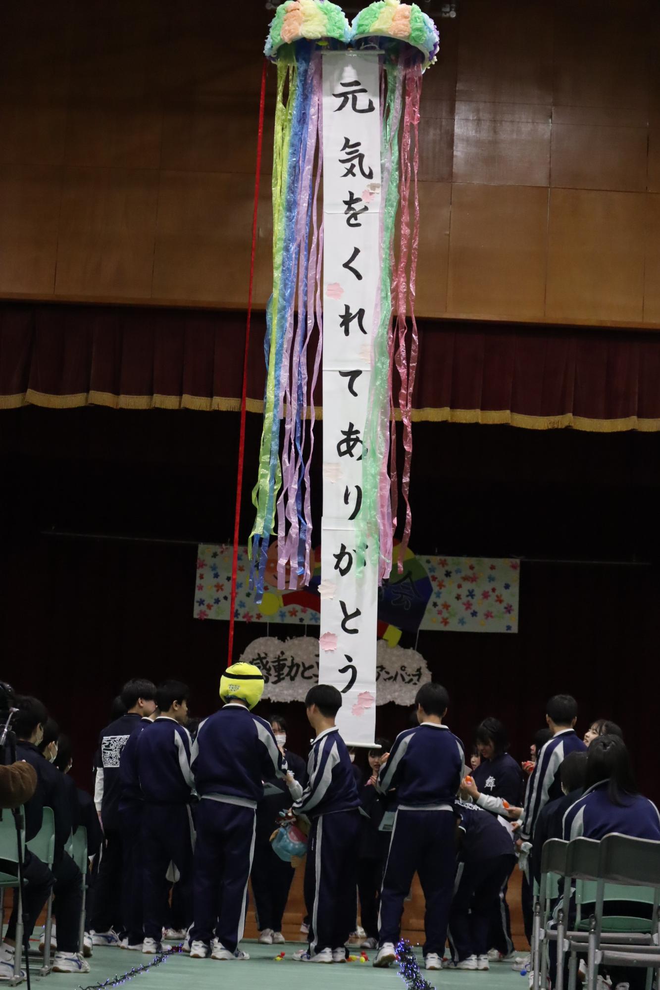 体育館の中央に「元気をくれてありがとう」と書かれたくす玉が飾られている写真