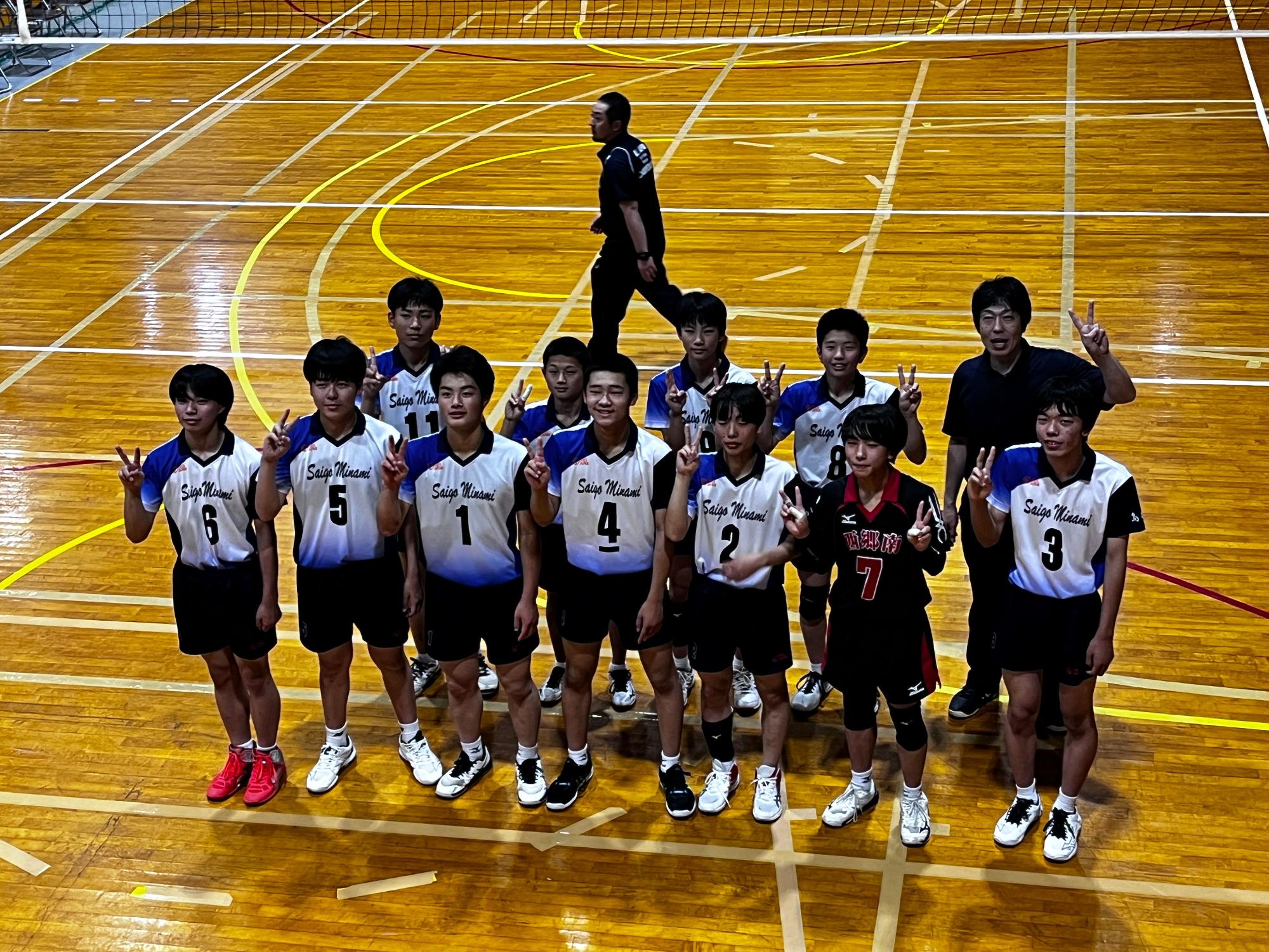 体育館で男子バレーボール部が記念撮影をしている写真