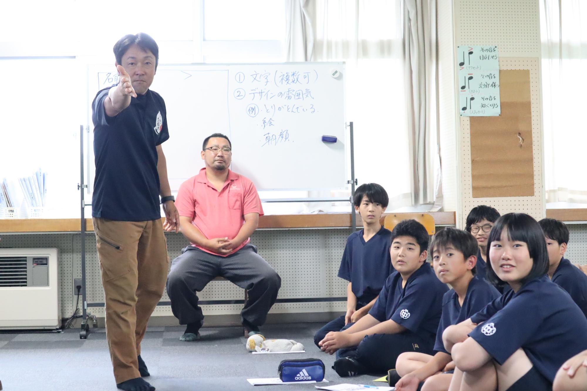 教室で先生が生徒に向かって指導している写真