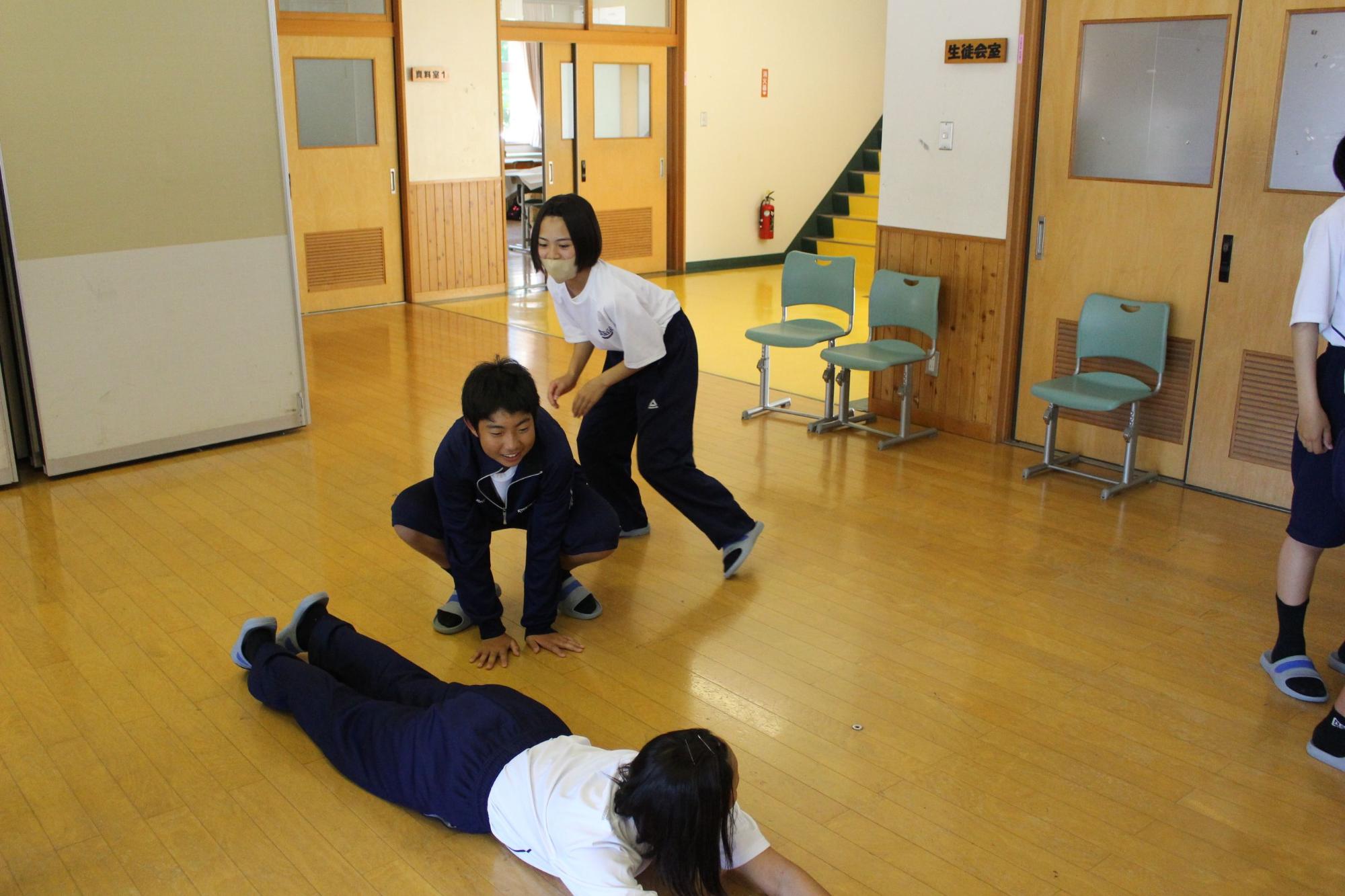 校舎内の廊下で生徒たちが体を使ったレクリエーションをしている写真