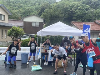 マラソン大会の給水所でランナーを笑顔で応援する生徒たちの写真