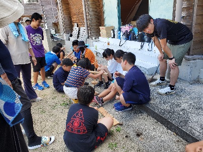 キャンプ場の建物前で子どもたちがグループになって話し合いをしている写真