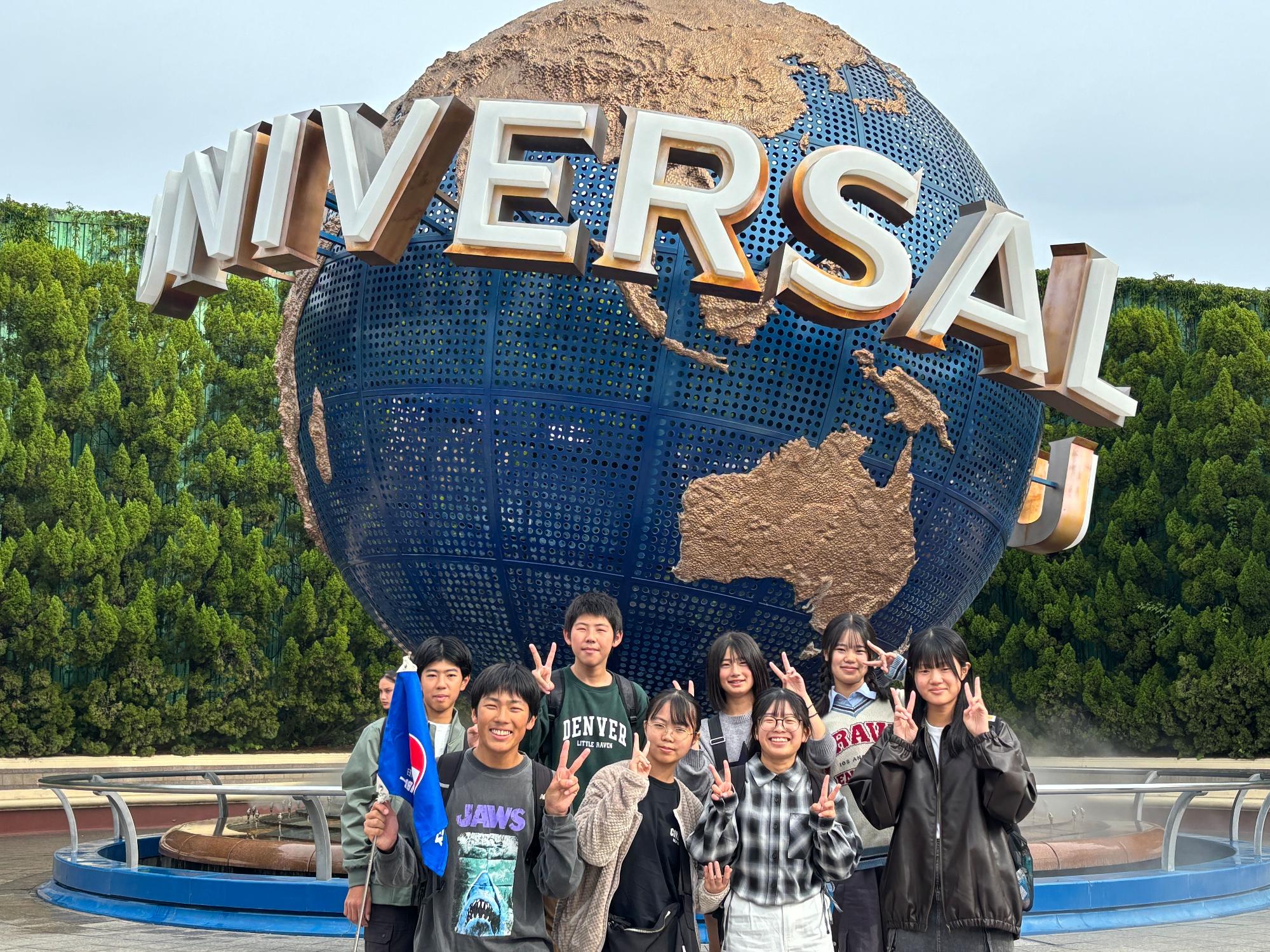 ユニバーサル・スタジオ・ジャパンの前で集合写真を撮る生徒たちの写真