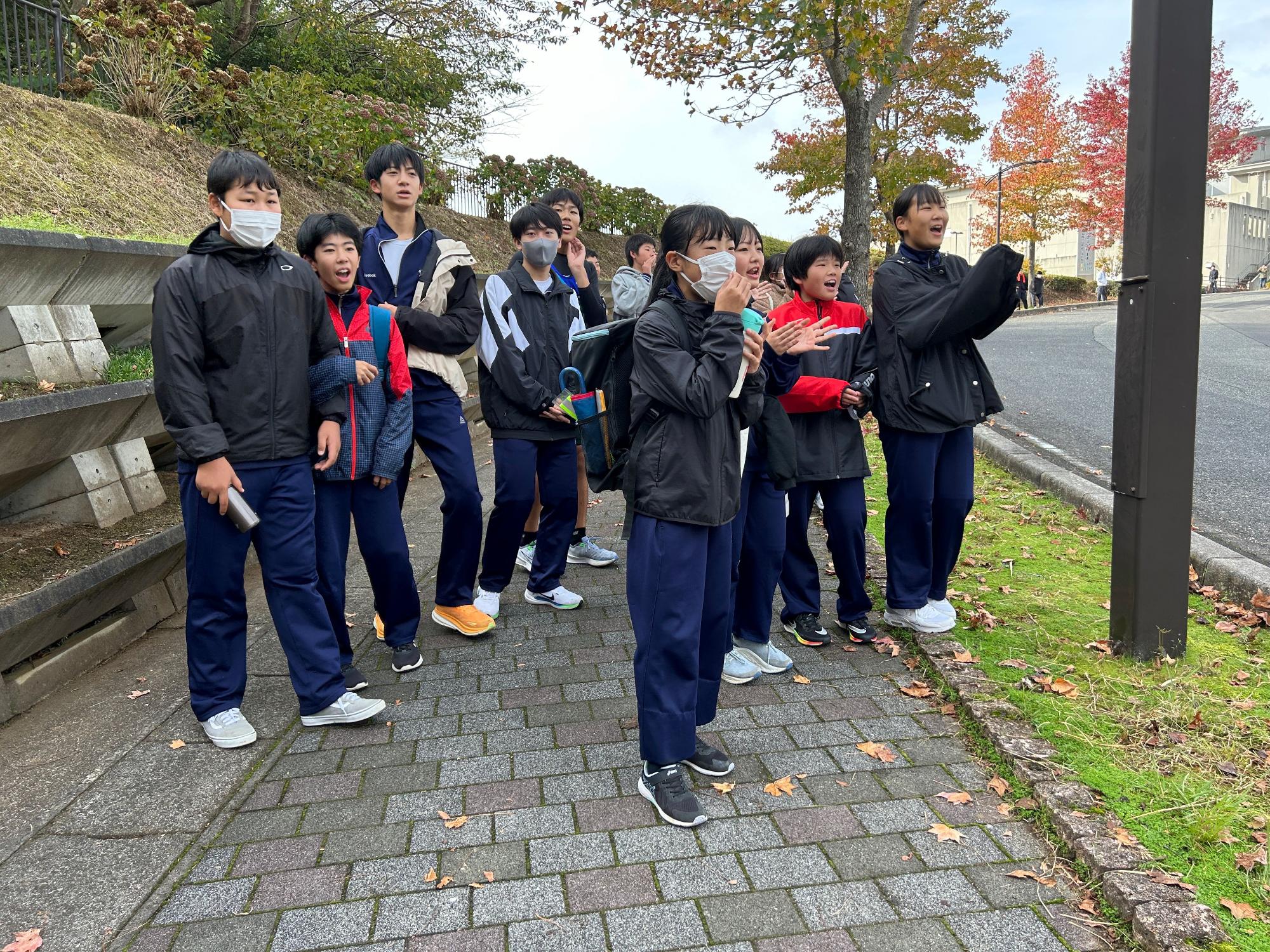 マラソン大会で仲間を応援している生徒たちの写真