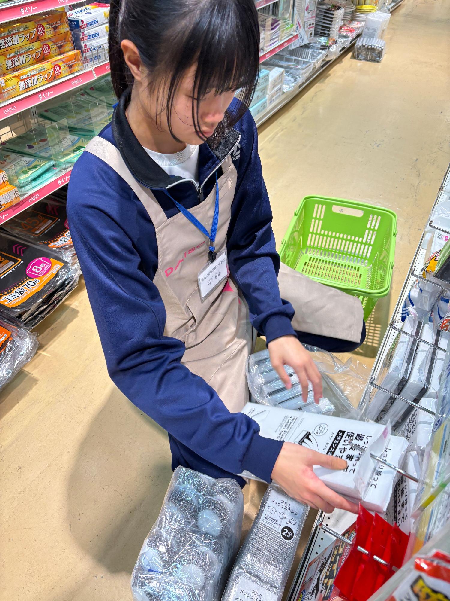店内で商品の陳列をしている生徒の写真