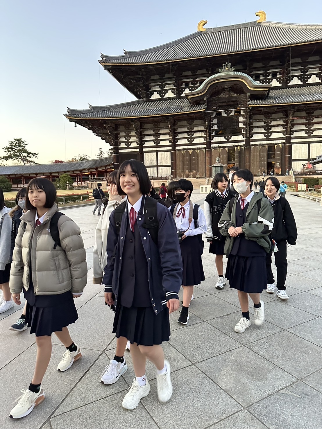 大仏殿の前を制服姿の生徒たちが見学している写真