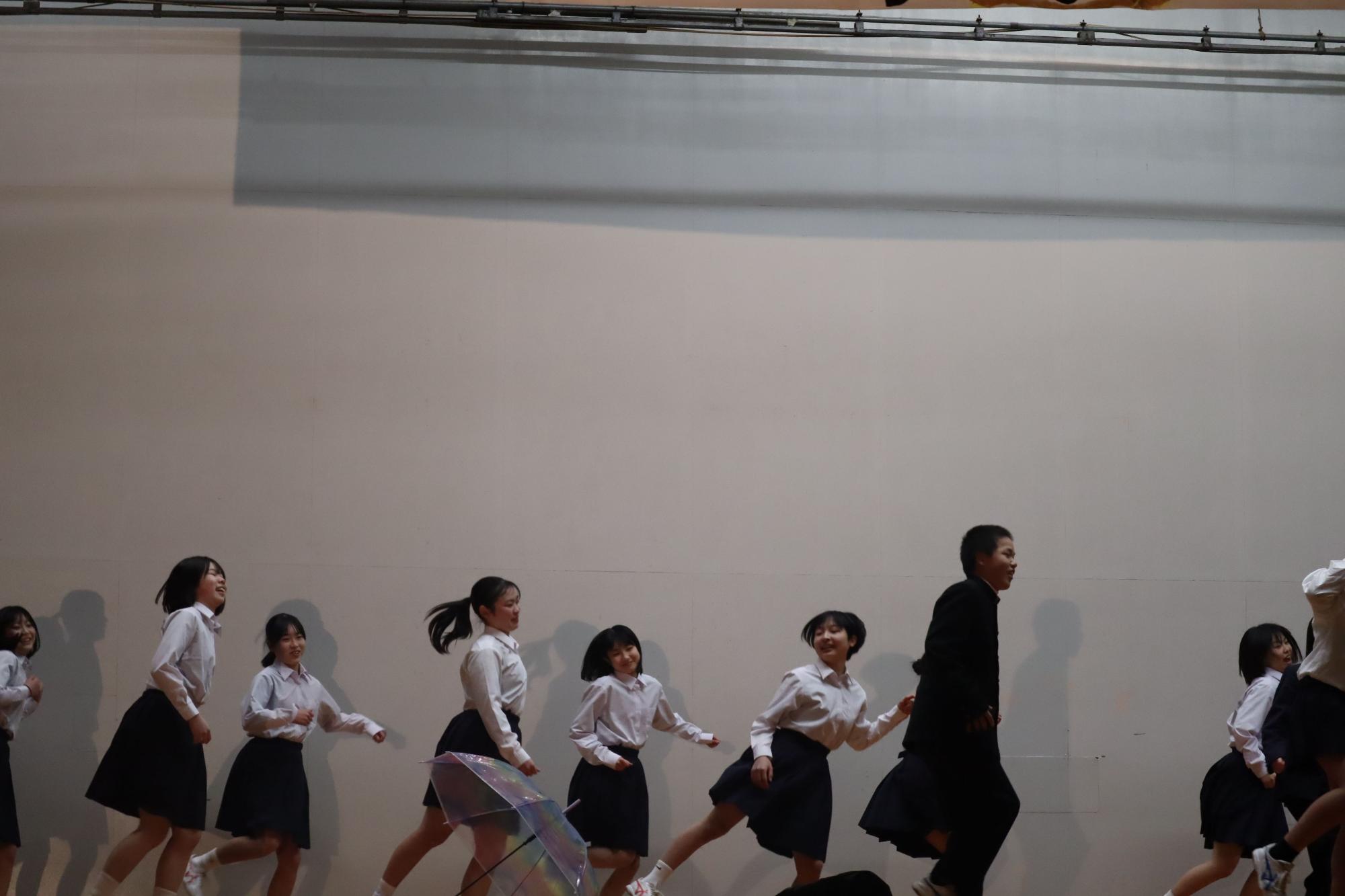 舞台上で生徒たちが楽しそうに踊っている写真