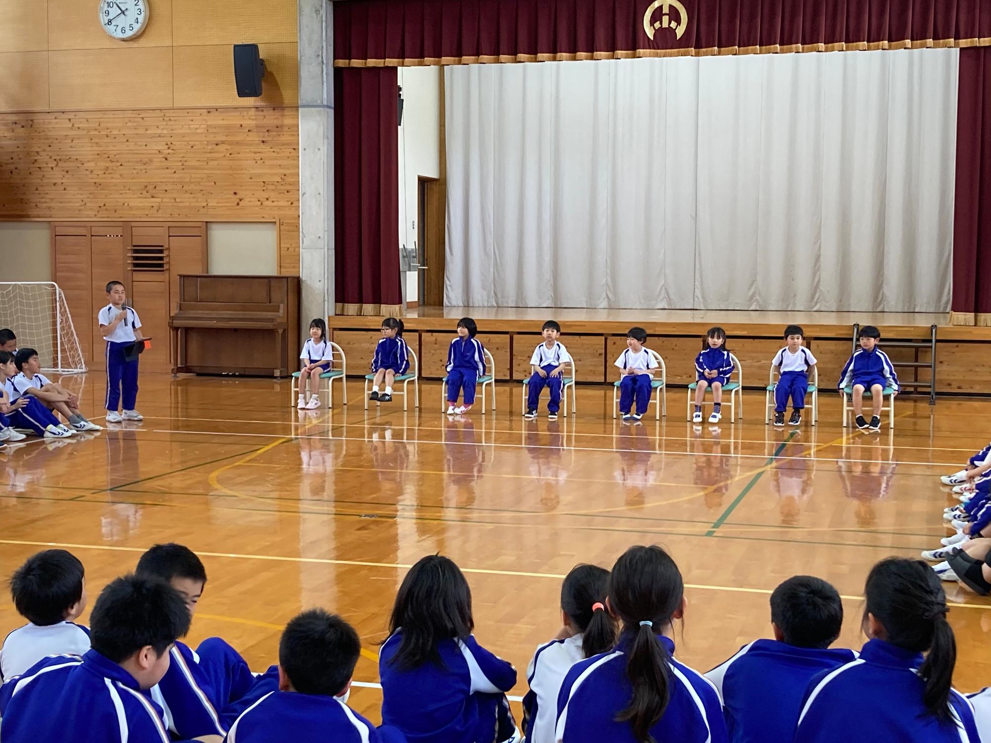 体育館で新入生が椅子に座って並んでいる写真