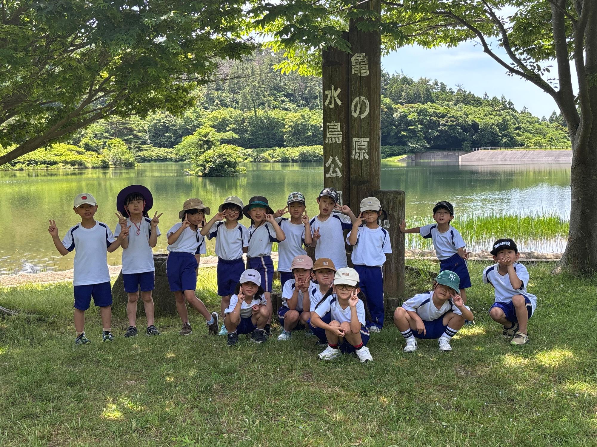 児童たちが「鶴の巣水源公園」と書かれたの看板の前に並んで記念撮影をしている写真