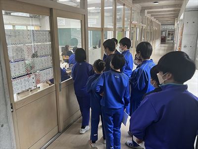 ガラス張りの教室を除く青ジャージを着た生徒たちの写真