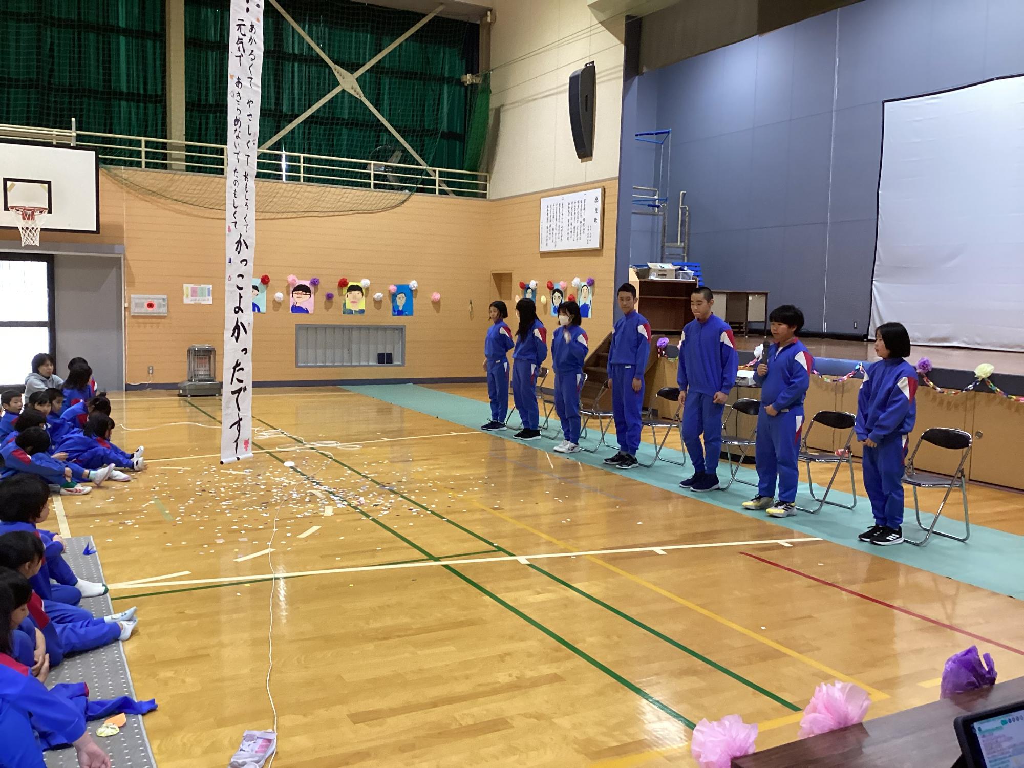 6年生を送る会にて割れたくす玉を児童たちで見ている写真