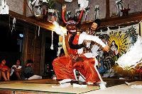 紅白の服装に赤い面をつけて舞っている様子の西村神楽の写真