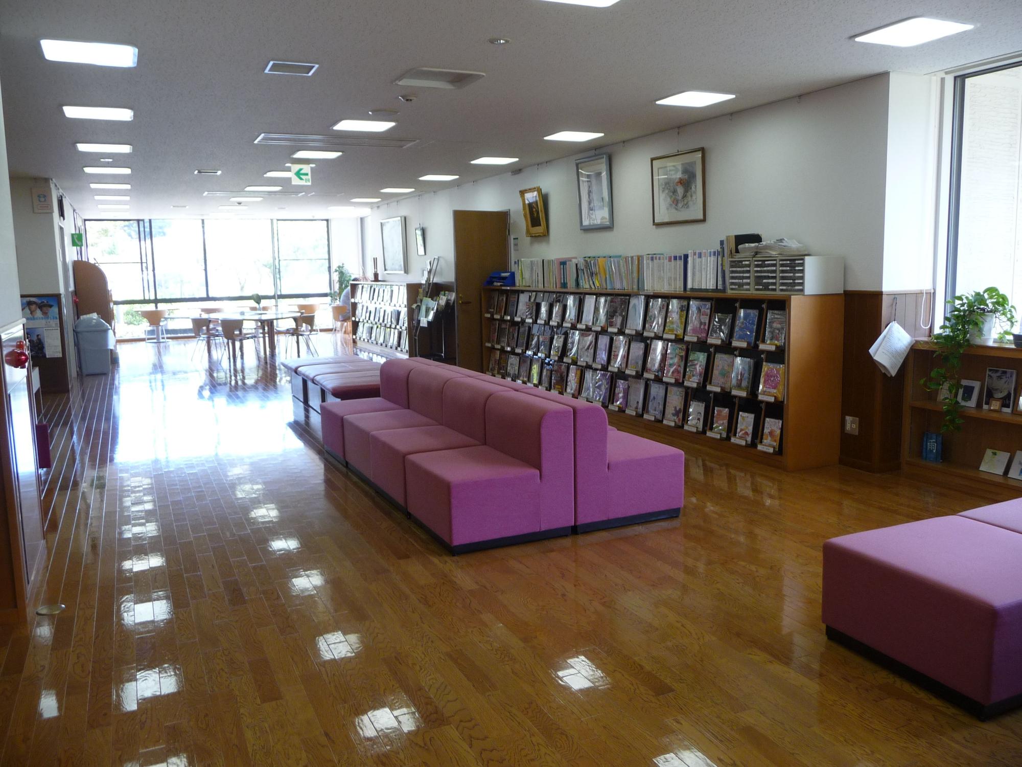 数台の紫色の長椅子が置かれた雑誌コーナーの写真