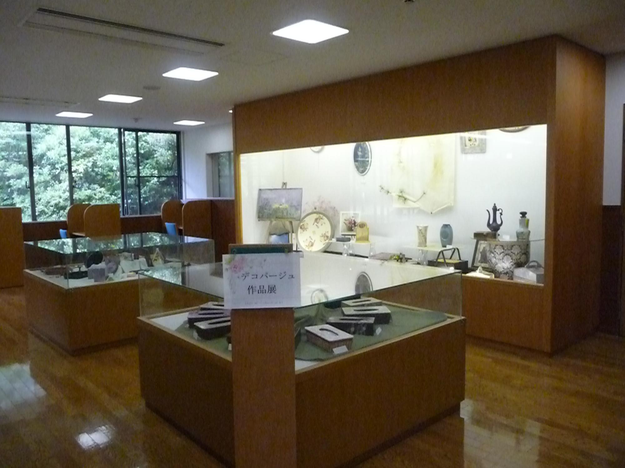 ガラスのショーケースの中にさまざまな作品が飾られている展示コーナーの写真