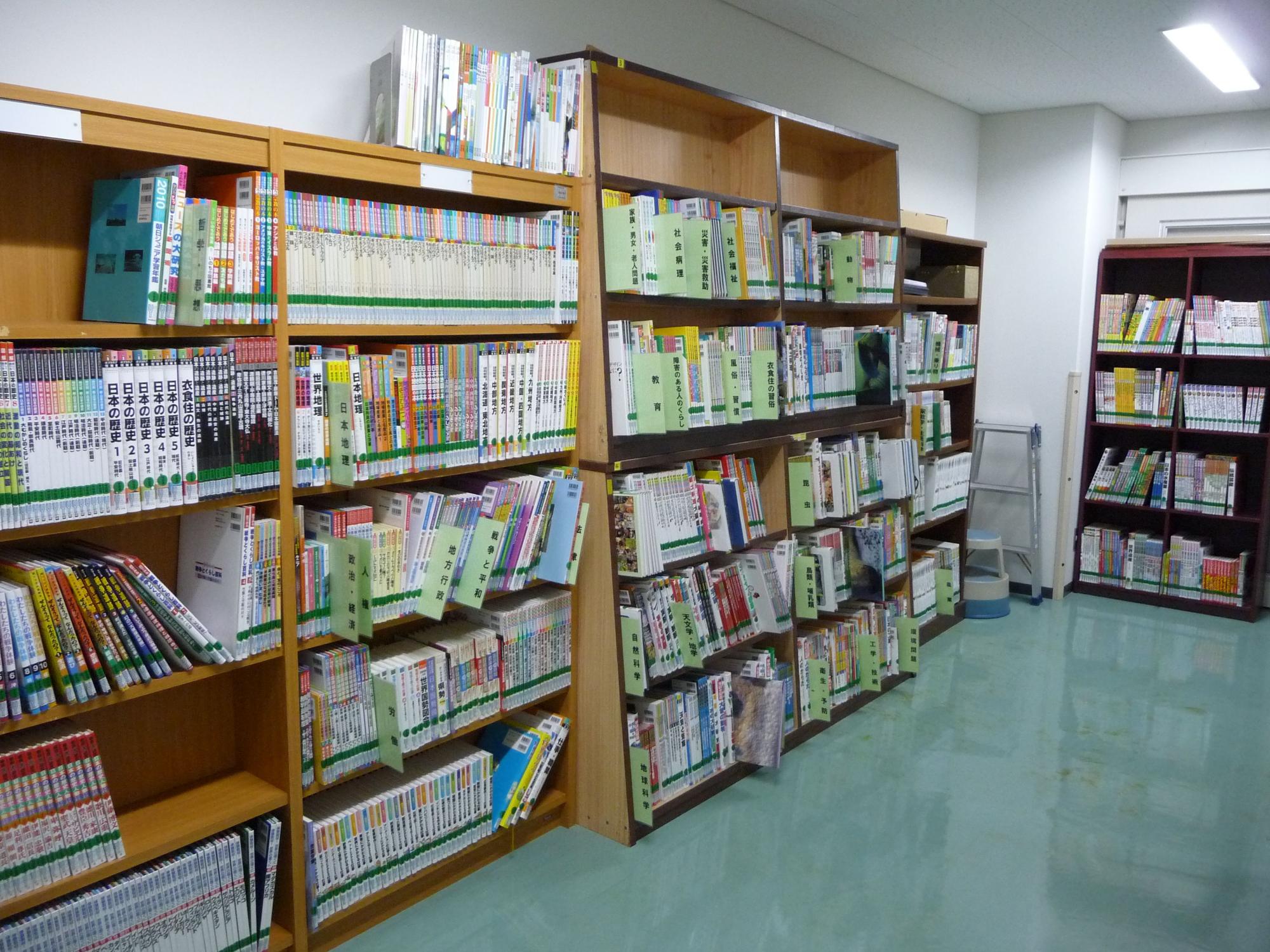 本棚にたくさんの本が配架されている学校図書館内の室内写真