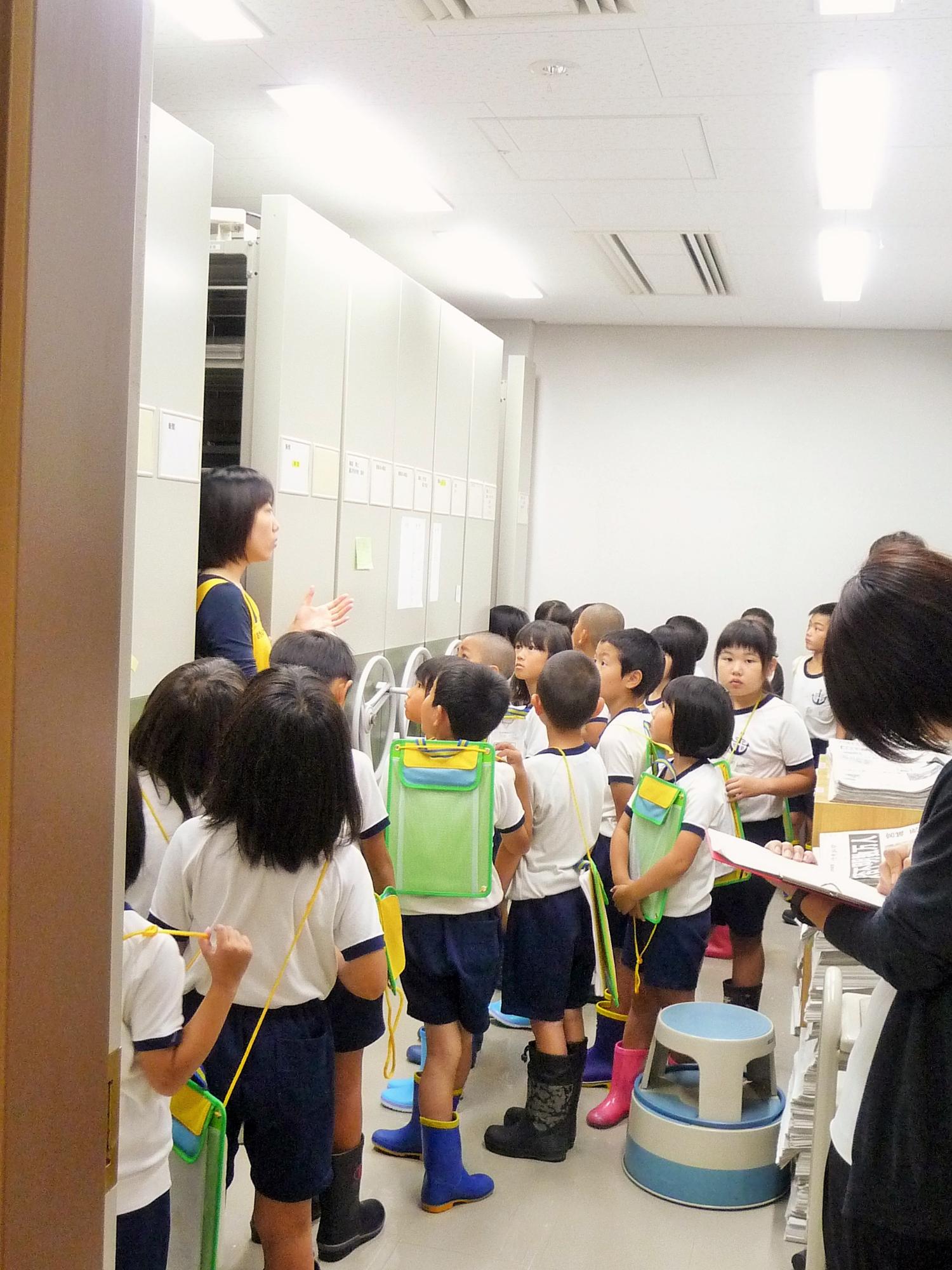 児童たちが図書館利用についての説明を受けている様子の写真