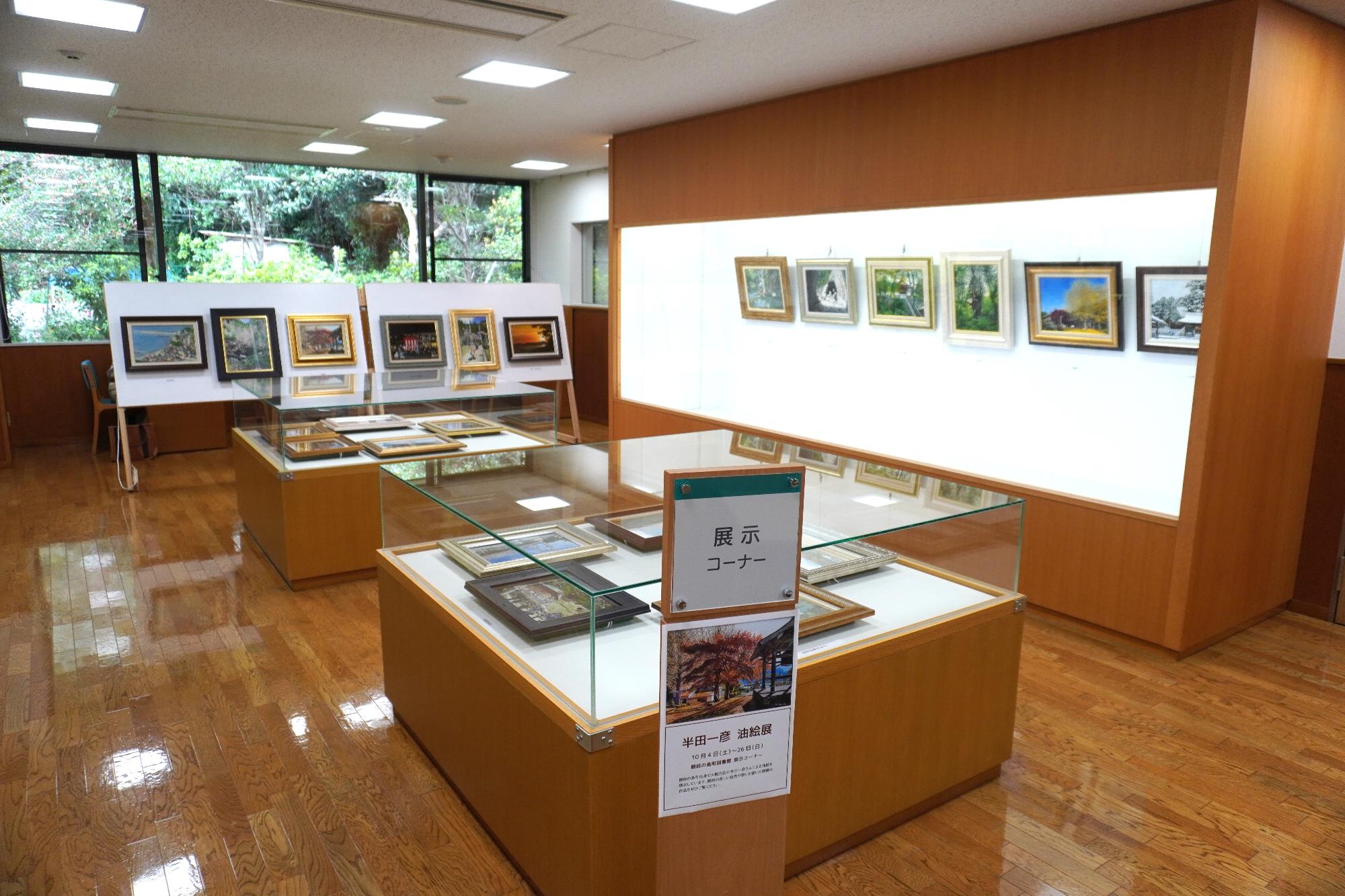 ガラスケース内にさまざまな絵が飾られている展示コーナーの写真