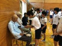 お年寄りと楽しそうに会話をしている体操着の児童たちの写真