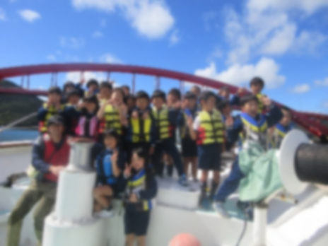 船上で救命胴衣を着た児童たちの集合写真