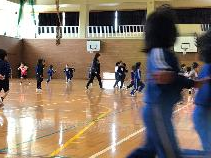 新一年生を迎え体育館で走り回って遊んでいる児童たちの写真