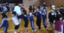 前の人の肩に手を乗せて体育館を歩いている児童たちの画像