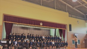 ステージ上で多数の児童が並び、歌をうたっている写真