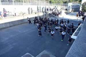 屋外で多数の児童が一斉に走っている写真