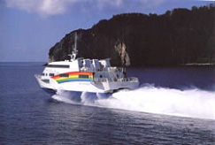 水しぶきをあげながら海上を走る白を基調とした船の写真