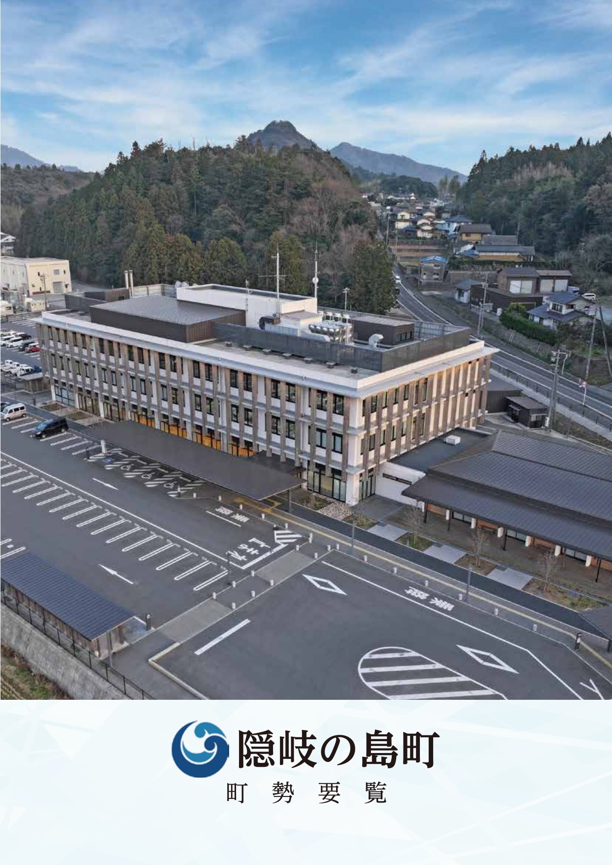 青空の下3階建ての大きな建物を俯瞰する形で撮影した写真の下に波の形をした隠岐の島町のロゴマークと隠岐の島町調整要覧と書かれた隠岐の島町調整要覧の表紙