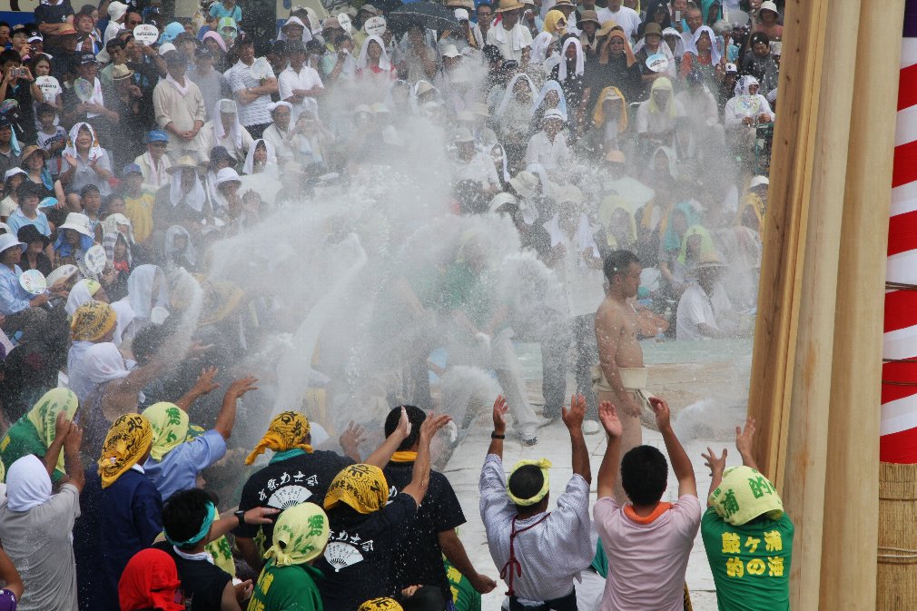 土俵に向かう力士に大量の塩をまいている人たちの写真