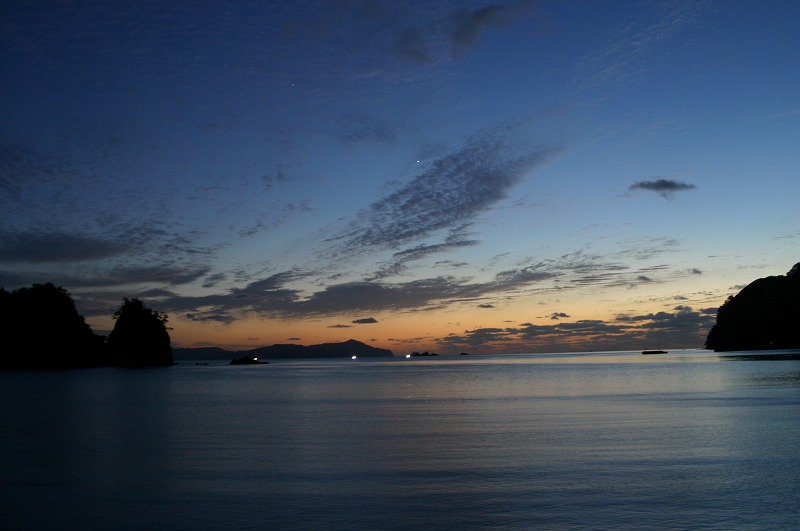 夕日が沈み暗くなっていく海の写真