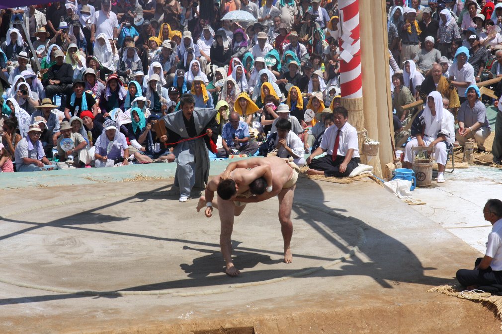 相手力士を掴んで投げようとしている力士を俯瞰視点で撮影した写真