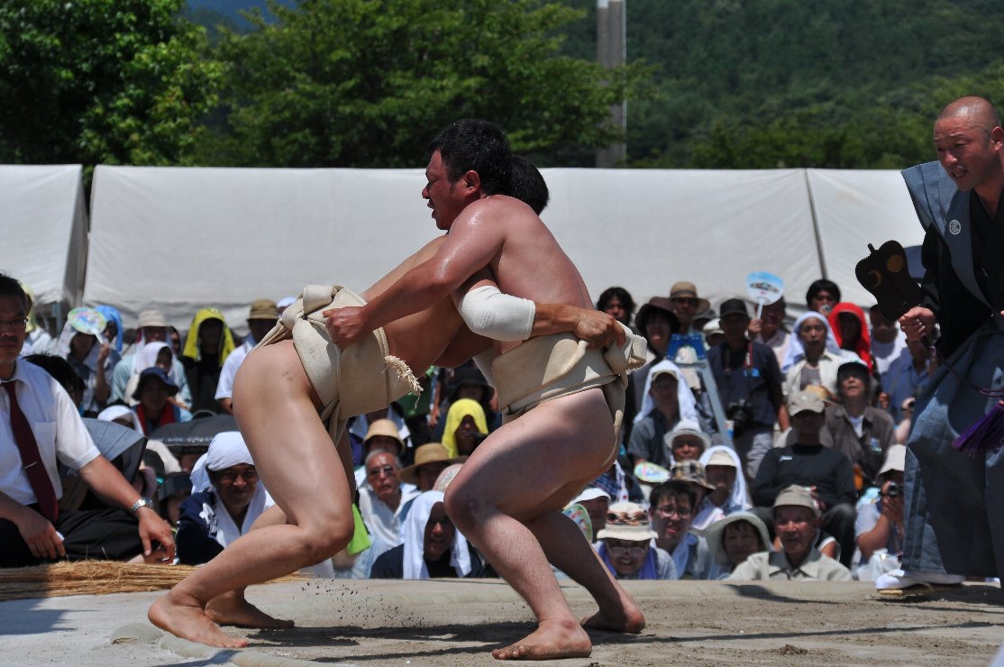 肘にサポーターを付けた力士が相手力士にぶつかっている写真