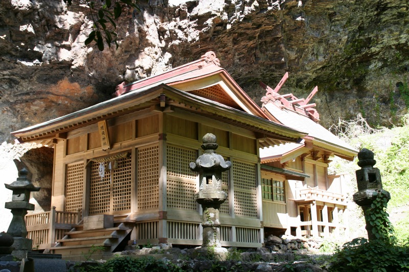 岩肌に囲まれた神社や灯篭の写真